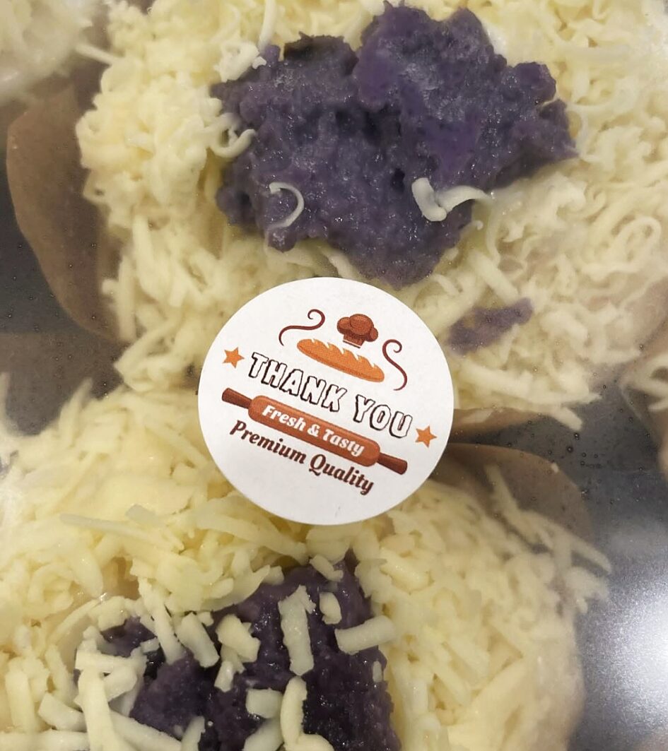 Ube-cheese ensaymada close-up with grated cheese and ube center
